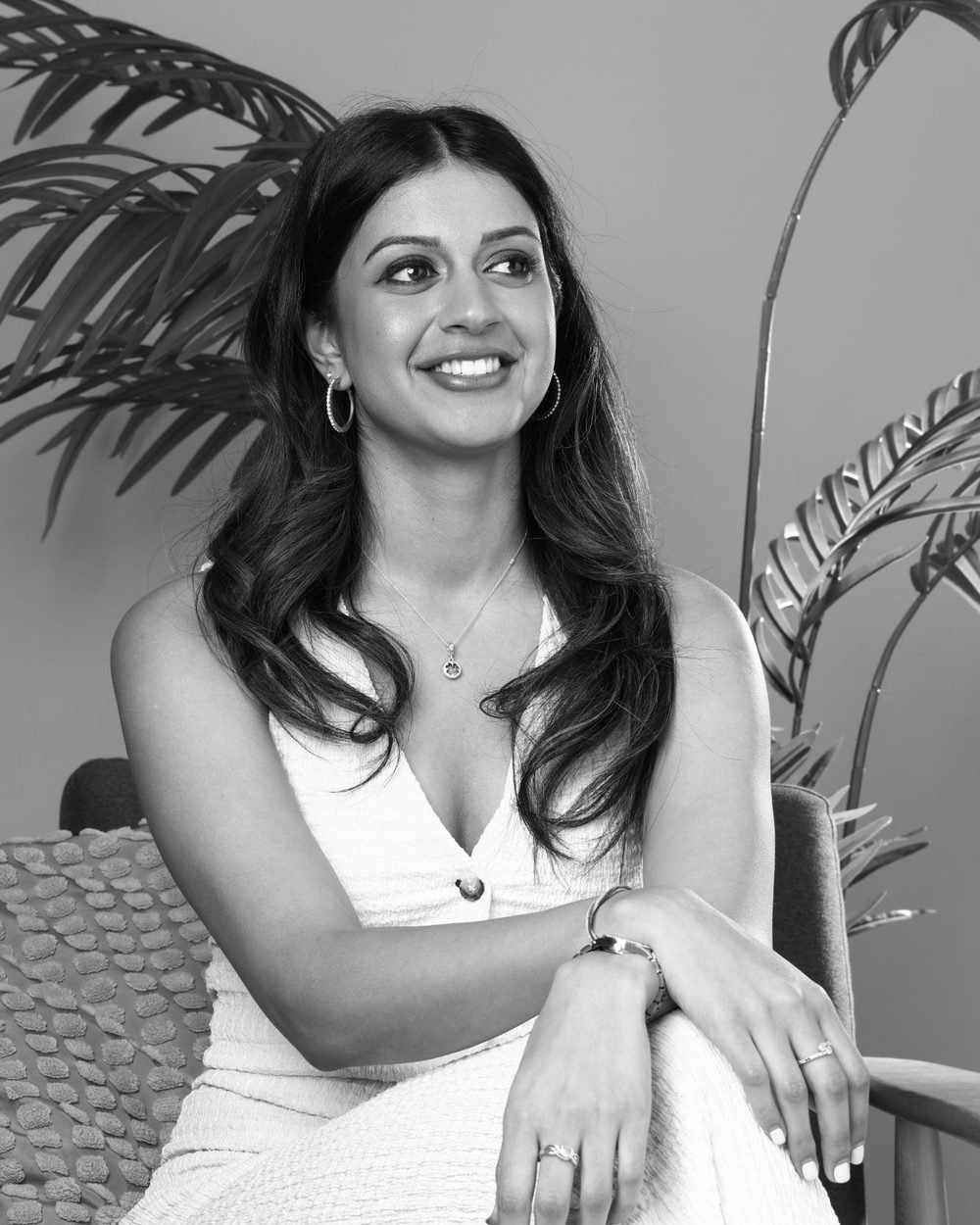 Meghna Kumar, founder of MK Influence, smiling in a white dress